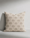 Beige pillow with palm tree pattern on a gray background